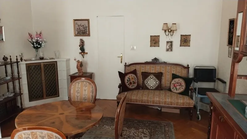 AntikLinz Linz – Ankauf von Antiquitäten und antiken Möbeln Antikes Wohnzimmer mit Biedermeier-Tisch, gepolstertem Sofa und Vitrine, bewertet von AntikLinz in Linz