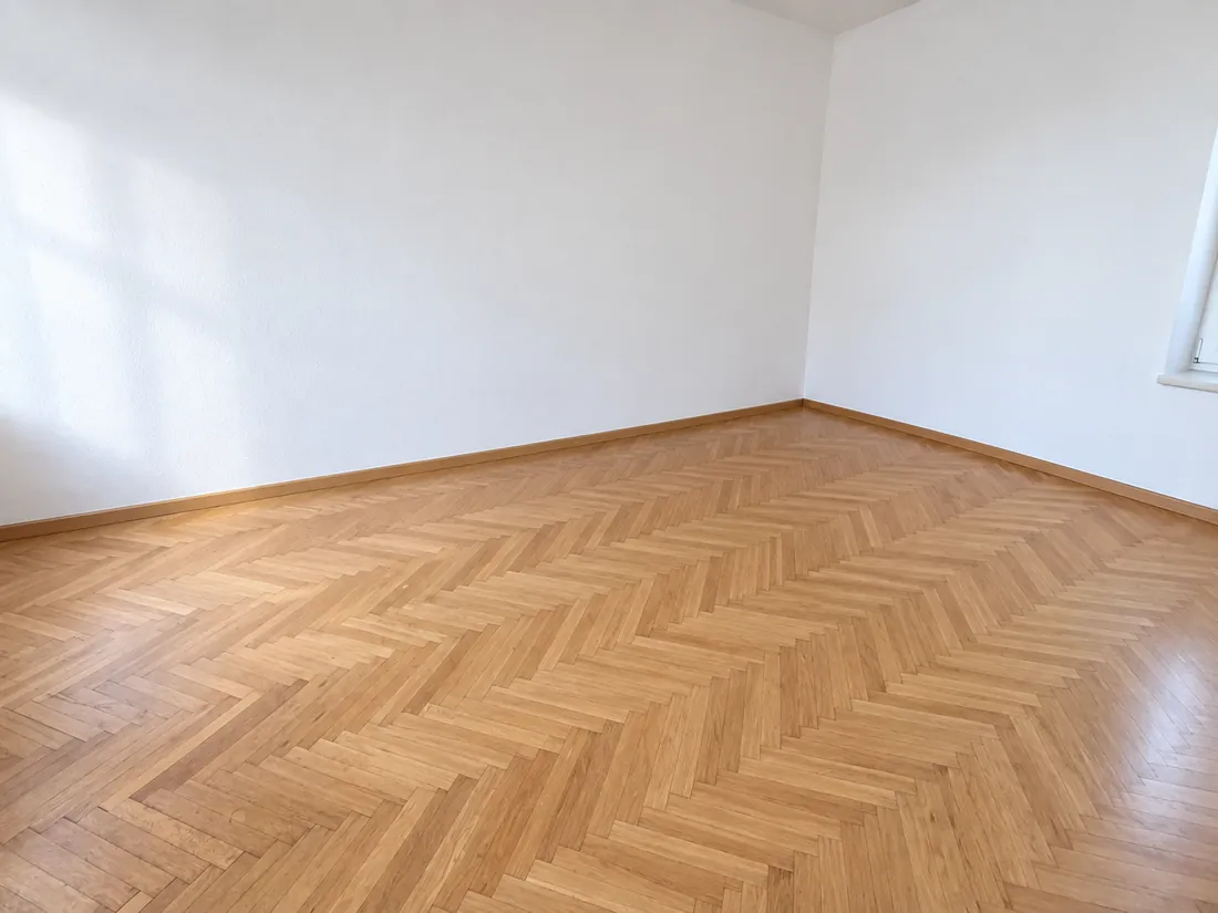 Schlafzimmer-Entrümpelung Linz: leeres, sauber übergebenes Zimmer mit Fischgrätparkett nach Abschluss der Arbeiten durch AntikLinz